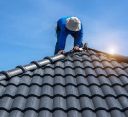 Roof,repair,,worker,with,white,gloves,replacing,gray,tiles,or