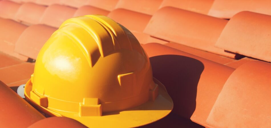 Professional,yellow,hard,hat,on,a,house,roof,.,construction